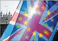  ?? [KIRSTY WIGGLESWOR­TH/ THE ASSOCIATED PRESS] ?? An anti-Brexit campaigner waves European Union and Union flags Wednesday outside Parliament in London.