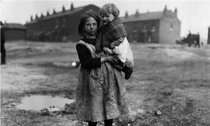  ?? ?? A miner's daughter carries a young child in her arms in Wigan during the coal strike of 1921. Photograph: Morey/Getty Images