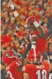  ?? AP PHOTO/JOSHUA L. JONES ?? Georgia wide receiver Tyler Simmons (87) celebrates with offensive guard Lamont Gaillard (53) and tight end Isaac Nauta (18) after scoring a touchdown in Saturday’s 27-10 win over Auburn.