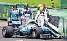  ??  ?? Walking away: Lewis Hamilton climbs from the wreckage of his Mercedes