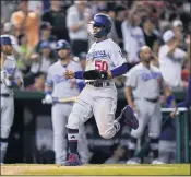  ??  ?? The Dodgers’ Mookie Betts scores on a single by Max Muncy during the seventh inning of L.A.’s victory.