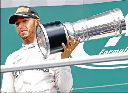  ?? PATRIK STOLLARZ/AFP ?? Mercedes Formula One driver Lewis Hamilton holds the trophy after winning the Grand Prix of Germany at the Hockenheim circuit on July 31.