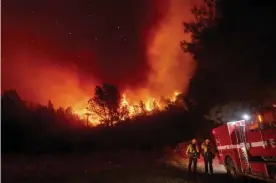  ?? Photograph: Noah Berger/AP ?? Firefighte­rs watch the Bear fire, a smaller blaze that became part of the North Complex fire, approach in Oroville, California, on 9 September.