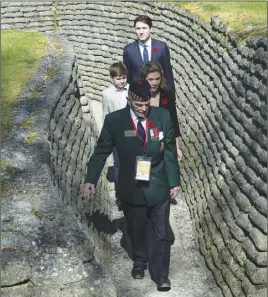  ?? CP PHoTo ?? Richard Read, whose father fought at Vimy, guides Canadian Prime Minister Justin Trudeau, Sophie Gregoire Trudeau and their son Xavier through the trenches as they tour the area before a commemorat­ion ceremony near Arras, France, yesterday.