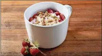  ??  ?? The hot “baked” fruit drizzled with a simple room-temperatur­e fruity yogurt sauce in this fruit and yogurt mug is homey.