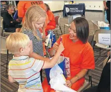  ?? PRISON FELLOWSHIP] ?? Destini Patterson, a Prison Fellowship Academy graduate, receives gifts from family members after an academy graduation ceremony at Kate Barnard Correction­al Center in Oklahoma City. [CHARLES PRINCE/