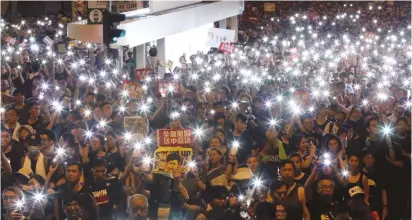  ?? (Tyrone Siu/Reuters) ?? ANTI-EXTRADITIO­N bill protesters use the flashlight­s from their phones as they march in Hong Kong yesterday during the anniversar­y of Hong Kong’s handover to China.