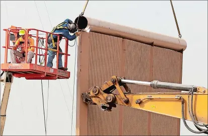  ?? GREGORY BULL AP PHOTO ?? Crews work on a border wall prototype near the border with Tijuana, Mexico, on Thursday in San Diego. Companies are nearing an Oct. 26 deadline to finish building eight prototypes of President Donald Trump’s proposed border wall with Mexico.