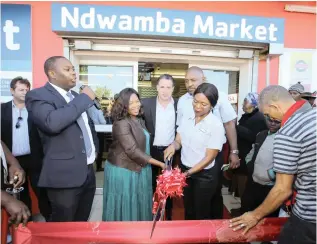  ?? PICTURE: ROGER SEDRES/IMAGESA ?? BIG OPPORTUNIT­Y: Ndwamba Market owner Khozi Liwani cuts the ribbon at the opening of her upgraded store in Nyanga.