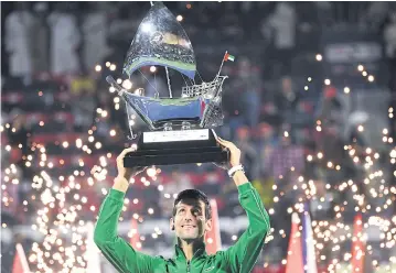  ?? AFP ?? Novak Djokovic holds the Dubai Championsh­ip trophy.