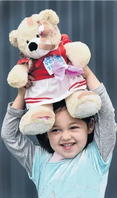  ?? PHOTO: PETER MCINTOSH ?? Bearing up . . . Santia Throp (3) happily holds aloft her bandaged bear after going to the Teddy Bear Hospital in Dunedin on Saturday.
