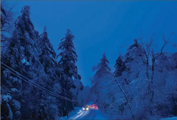  ?? (File Photo/AP/Robert F. Bukaty) ?? Utility crews prepare to work on power lines Dec. 26, 2013, at dusk in Litchfield, Maine, where many had been without electricit­y since a storm earlier in the week.