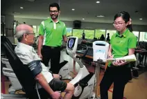  ??  ?? Staff nurses watch as an elderly patient does rehabilita­tion exercises at the Ren Ci community hospital.