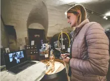  ?? ANNE-CHRISTINE POUJOULAT/AFP VIA GETTY IMAGES ?? Chateau Barbebelle winemaker Madeleine Premmereur presents bottles of wine during a tasting by video conference with customers in Rognes, France.