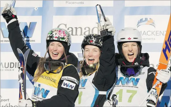  ?? — THE CANADIAN PRESS ?? Moguls winner Justine Dufour-Lapointe, centre, is flanked on the podium by her sisters, second-place winner Chloe, left, and third-place finisher Maxime at the World Cup moguls event Saturday in Val Saint-Come, Que.