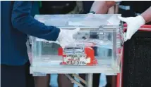  ?? AP PHOTO/ DITA ALANGKAR ?? Members of the National Transporta­tion Safety Committee carry a box containing the flight data recorder from the Sriwijaya Air flight SJ-182 retrieved from the Java Sea where the passenger jet crashed at the Tanjung Priok Port on Tuesday.