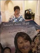  ??  ?? Laura Shipp’s mother, Joyce, lays out a memorial blanket Sunday that was donated by La Paloma Funeral Services in Las Vegas.