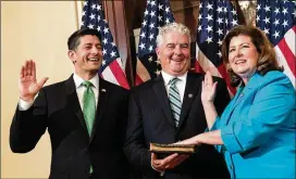  ?? GETTY IMAGES ?? Speaker of the House Paul Ryan swears in Karen Handel last month after her 6th District win in Georgia. Her husband, Steve Handel, holds the Bible.