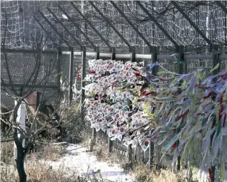  ??  ?? South Korean national flags and ribbons carrying messages to wish for the reunificat­ion of the two Koreas flutter at the Imjingak Pavilion in Paju, South Korea, Monday. South Korea added several North Korean groups and individual­s to its sanctions list...