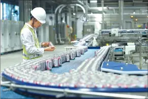  ?? PROVIDED TO CHINA DAILY ?? A worker checks cans of beer at a brewery of Anheuser-Busch InBev located in China.