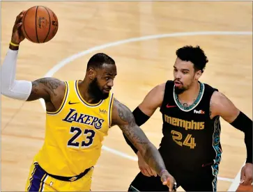  ?? AP PHOTO BY BRANDON DILL ?? Los Angeles Lakers forward Lebron James (23) handles the ball against Memphis Grizzlies guard Dillon Brooks (24) in the second half of an NBA basketball game Tuesday, Jan. 5, in Memphis, Tenn.