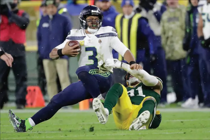  ?? AARON GASH / ASSOCIATED PRESS ?? Seattle Seahawks quarterbac­k Russell Wilson is sacked by Green Bay Packers linebacker Preston Smith on Sunday in Green Bay, Wis. The Packers won 17-0 in Wilson’s first game back since finger surgery sidelined him for three games.