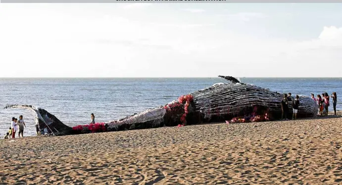  ?? —LYN RILLON ?? Residents of Naic, Cavite woke up to this sight of a dead whale which turned out to be an art installati­on put up to raise awareness on pollution caused by plastics worldwide.