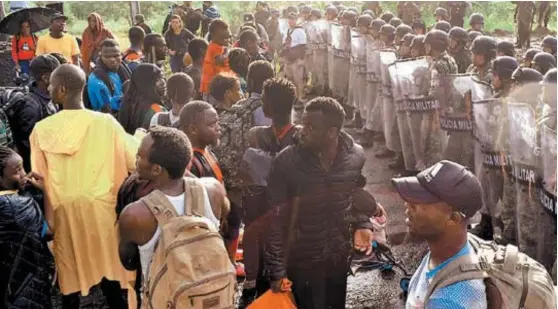  ?? REUTERS ?? Los migrantes estuvieron 20 minutos frente al cerco policiaco para pedir libre paso, aunque finalmente se replegaron.