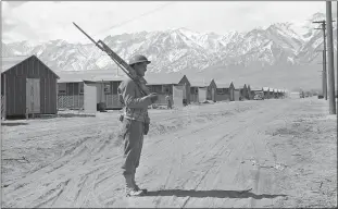  ?? THE ASSOCIATED PRESS ?? An American soldier guards a Japanese American internment camp at Manzanar in May 1943.