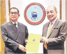  ?? ?? Ongkili (left) receiving his appointmen­t letter from Hajiji.