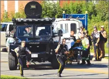  ?? Keith Minchin/AP ?? Shooting: Police officers and paramedics survey the area of a shooting in Fredericto­n, New Brunswick, Canada on Friday, Aug. 10, 2018. Fredericto­n police say two officers were among four people who died in a shooting Friday in a residentia­l area on the city's north side. One person was in custody, they said, and there was no further threat to the public.