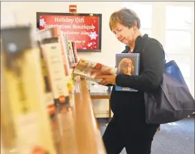  ??  ?? Barbara Bessinger, of Woodbridge, peruses the bookshelve­s.