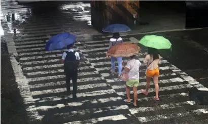  ?? PHOTOGRAPH BY ANALY LABOR FOR THE DAILY TRIBUNE @tribunephl_ana ?? PEDESTRIAN­S crossing EDSA brave the heavy rains brought by tropical depression ‘Carina.’