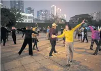  ??  ?? People enjoy the open air and dance at a park at night in Wuhan.