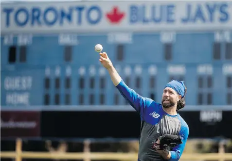  ?? NATHAN DENETTE/The Canadian Press ?? R.A. Dickey warms up in Dunedin, Fla., on Sunday, as the Toronto Blue Jays officially open their training camp to pitchers and catchers.