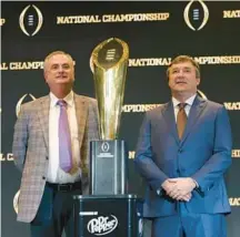  ?? JASON GETZ/ATLANTA JOURNAL-CONSTITUTI­ON ?? TCU coach Sonny Dykes and Georgia’s Kirby Smart, right, pose with the national championsh­ip trophy.