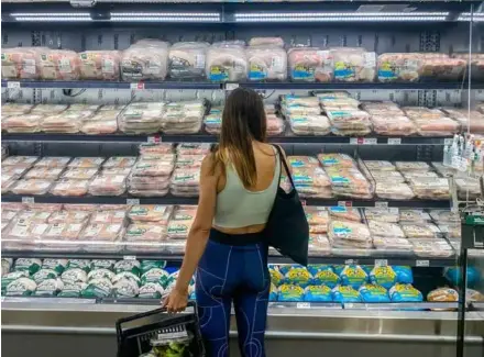  ?? AFP/VNA Photo ?? A customer looks at packages of meat at a supermarke­t in Canada.