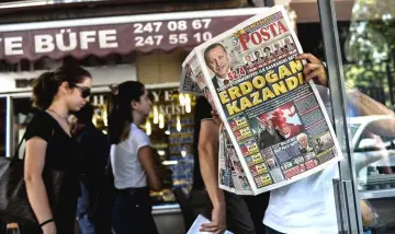  ??  ?? A man reads a daily newspaper with the results of the presidenti­al and parliament­ary elections on front page in Istanbul. — AFP photo