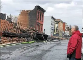  ?? NICHOLAS BUONANNO — NBUONANNO@TROYRECORD.COM ?? On Friday morning, Cohoes Mayor Shawn Morse looks over some of the damage caused by a blaze that affected over 20 buildings in downtown Cohoes Thursday afternoon. A Cohoes resident, John Gomes, has been charged with arson.