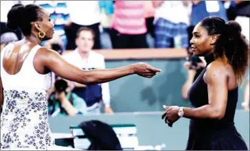  ?? DJANSEZIAN/GETTY IMAGES/AFP KEVORK ?? Venus Williams (left) offers her sister Serena a hug after Venus’s victory at Indian Wells on Monday.