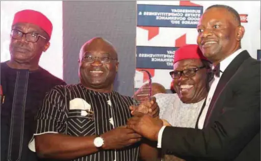  ??  ?? Ikpeazu (2nd right) receiving the award of the best state in the promotion of made in Nigeria goods and best state in the promotion of SME from the publisher of Business Day Newspaper, Mr. Frank Aigboun (1st left), assisted by a former Senate...