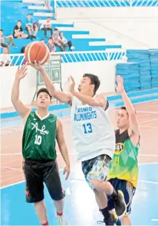  ?? JESSIE HENRY CASTILLO PHOTO/BASKETBALL AVENUE ?? RIGHT ON TIME. Jarius Guingguing shoots against two Spartans during the resumption of of Basketball Avenue Open Basketball Tournament at the Almendras Gym Davao City Recreation Center yesterday.