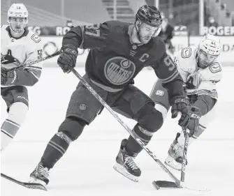  ?? PERRY NELSON • USA TODAY SPORTS ?? Edmonton Oilers forward Connor Mcdavid, seen here battling for the puck against Vancouver Canucks forward Tyler Graovac on Saturday night, has shifted his focus to a successful playoff run.