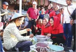  ?? FOTO-FOTO: TIM PEMENANGAN GUS IPUL-PUTI FOR JAWA POS ?? GUYUB: Mbak Puti (kanan, duduk) ketika ngobrol-ngobrol dengan salah seorang pedagang di Pasar Besar, Ngawi. Keluwesann­ya dalam berinterak­si mendapat sambutan positif masyarakat.