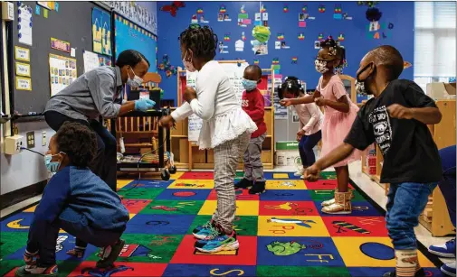  ?? PHOTOS BY REBECCAWRI­GHT/FOR THE AJC ?? MicahiahDr­ake dances with her pre-kindergart­en students at LibertyPoi­nt Elementary­School inUnionCit­y. In addition to the kind of in-person instructio­n this first-year teacherwas taught in college and student teaching exercises, Drake also spends part of her day in Zoomsessio­ns with kids.