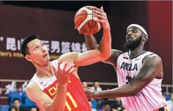  ?? XINHUA ?? Yi Jianlian grapples for possession during China’s 73-62 victory over Angola in a World Cup warmup match in Kunshan, Jiangsu province, on Saturday.