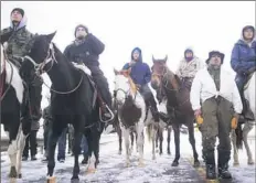  ?? Cassi Alexandra/The New York Times ?? Protesters at the Oceti Sakowin camp face off with police Friday just outside the Standing Rock Sioux Reservatio­n in Cannon Ball, N.D.