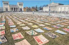  ?? FOTO: WOLFGANG MARIA WEBER/IMAGO ?? Kunstaktio­n von Fridays for Future am Freitag während einer Kundgebung in München: Hunderte Plakate zu Klima, Politik und Umwelt bedecken die Hälfte der Fläche auf dem Königsplat­z.