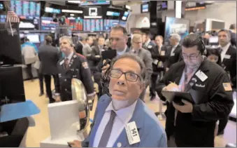  ?? -AFP ?? Traders work on the floor of New York Stock Exchange.