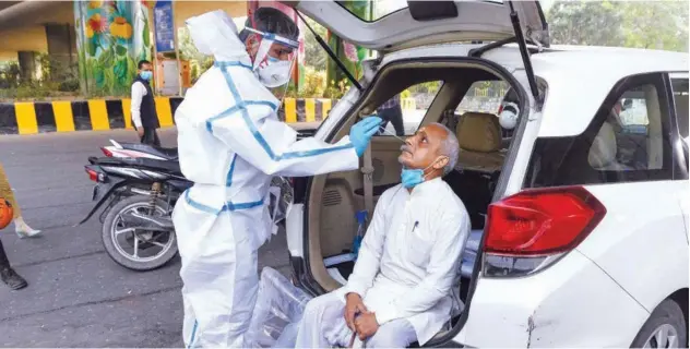  ?? Agence France-presse ?? ↑
A medical worker collects a nasal swab sample from a man in Noida on Wednesday.